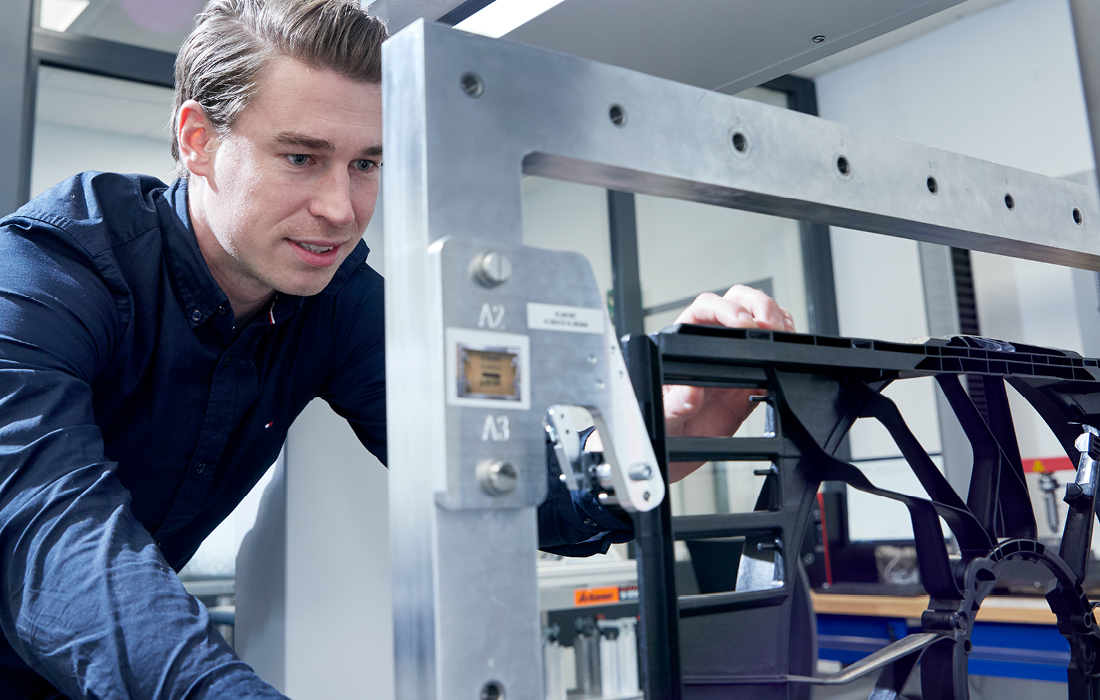 Ein Mann der ein Formteil betrachtet.